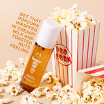 Butter Me Up Fragrance Mist - The Body Shop, leaning on a popcorn box. Overlay text 'Get that popcorn wrapped in creamy milk and toasted nuts feeling'.